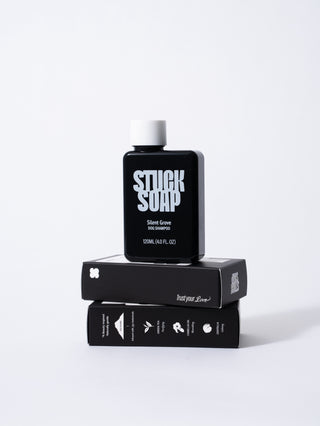 Black Silent Grove 120 ml bottle standing on two stacked shampoo cartons