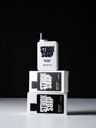 White Blush Garden 120 ml bottle balanced on two stacked cartons against a black background