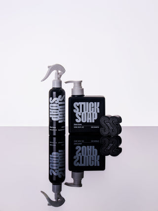 Black Silent Grove spray bottle, 500 ml pump bottle and black soap bar on a reflective white surface