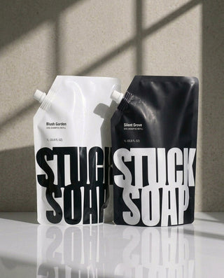White Blush Garden and black Silent Grove 1 L refill pouches side by side in sunlight