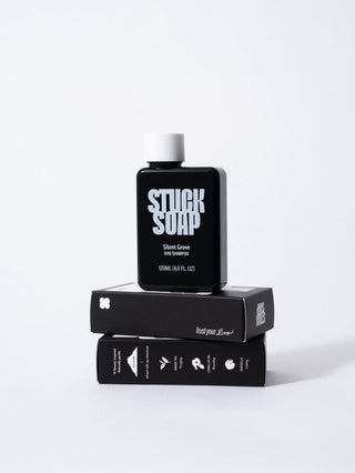 Black Silent Grove 120 ml bottle standing on two stacked cartons on a white surface